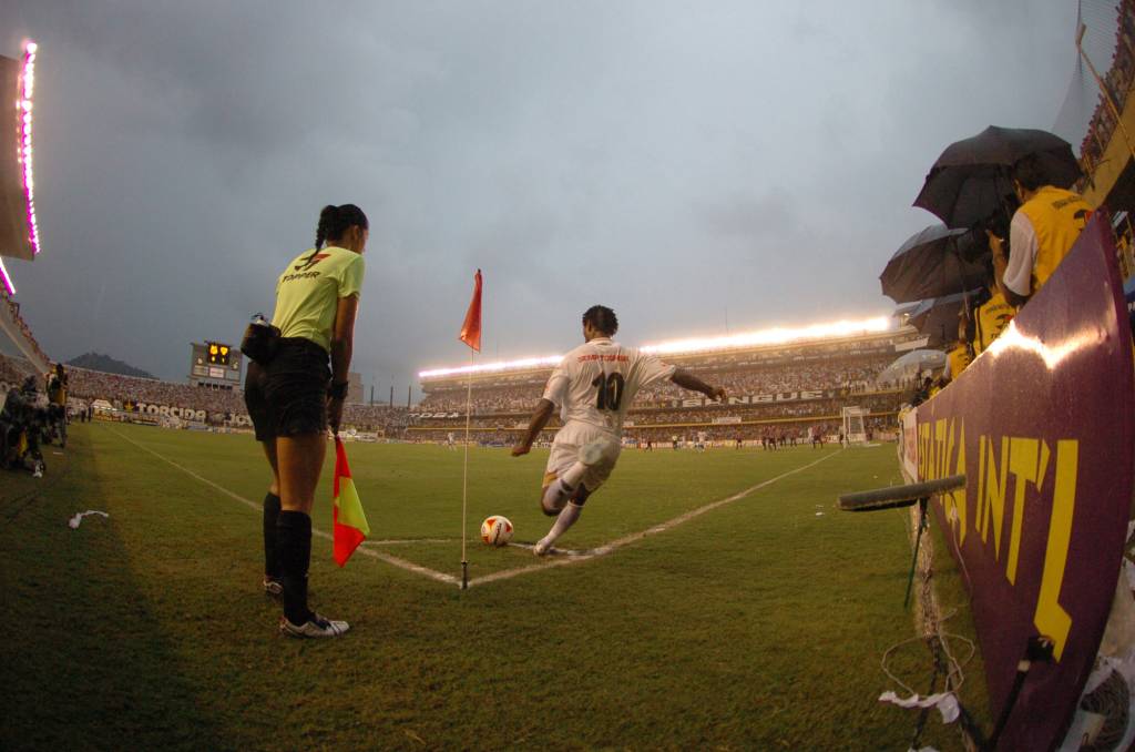 Zé Roberto, do Santos, batendo escanteio, ao lado da bandeirinha Ana Paula dos Santos Oliveira, durante jogo contra o São Paulo, pelo Campeonato Paulista de Futebol, no Estádio da Vila Belmiro.
